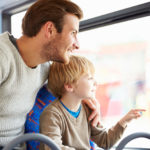 Happy Smiling Father And Son Enjoying Bus Journey Together